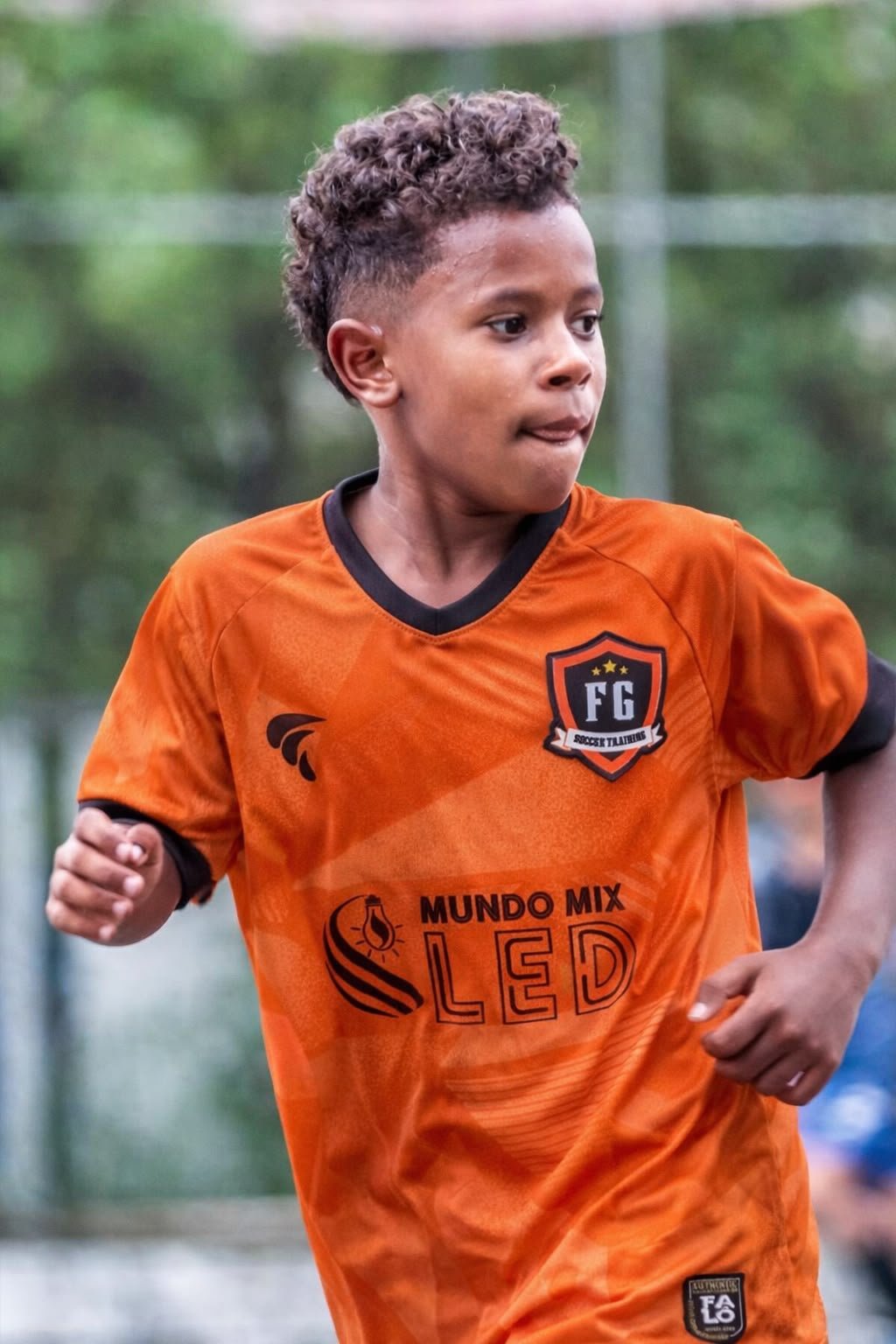 Kaká em ação com o uniforme laranja da FG Soccer Training durante partida