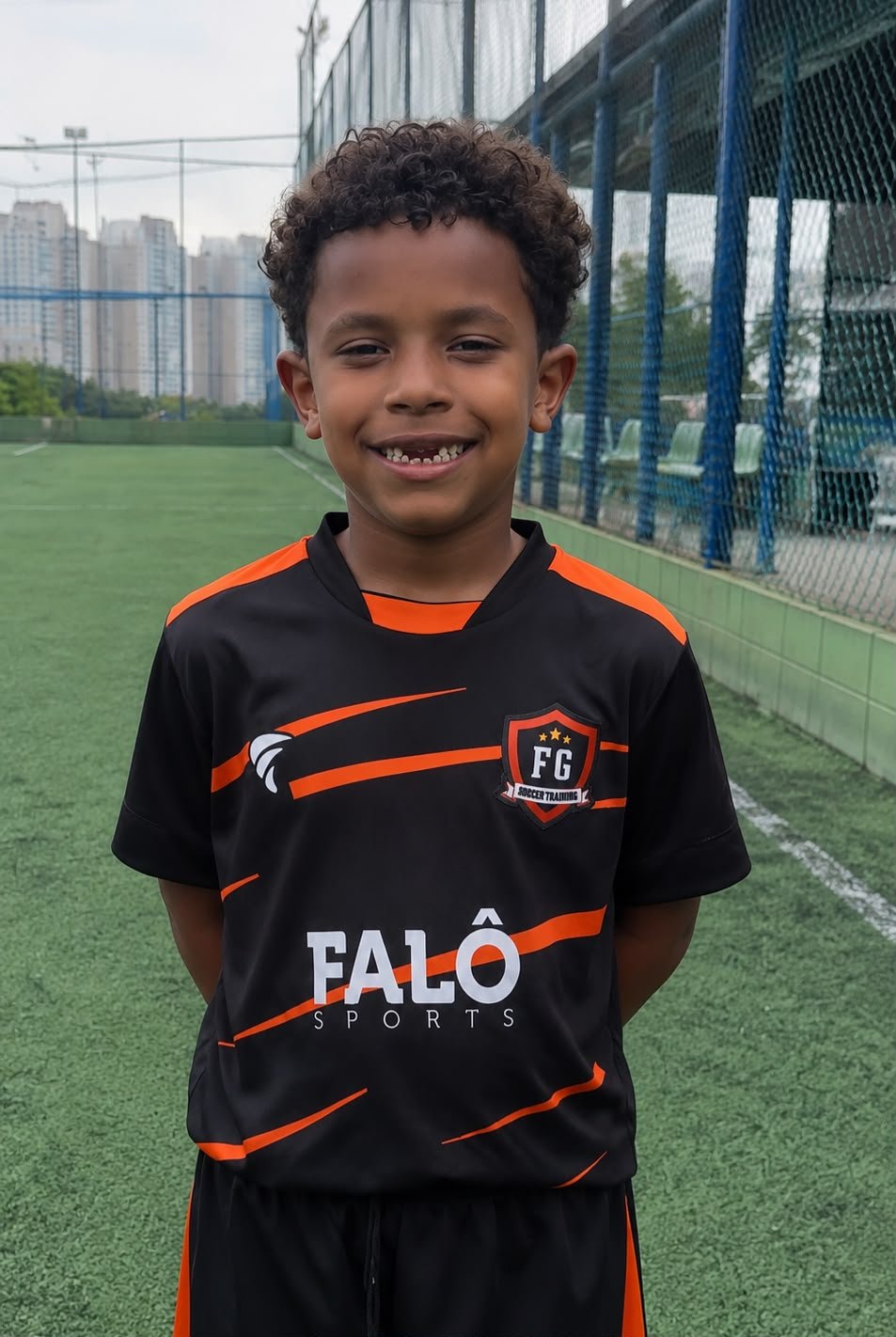Kaká posando em campo com o uniforme preto e laranja da FG Soccer Training